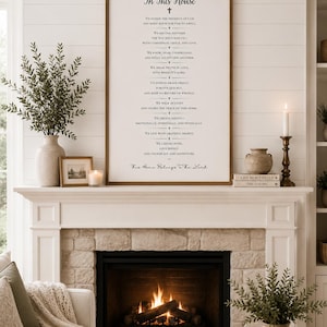 Könnte beinhalten: Ein rechteckiges Wandschild mit einem dunklen Holzrahmen und schwarzem Text auf weißem Hintergrund. Der Text lautet In This House, gefolgt von einer Liste von Hausregeln und dem Satz His Home Belongs To The Lord, zentriert über einem Kamin.