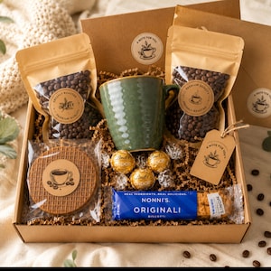 May include: A gift box containing a green ceramic mug, two pouches of roasted coffee beans, a round waffle cookie, three gold-wrapped Lindt chocolates, and a blue Nonni's Originali biscotti package. Each item features a label with a coffee cup icon.