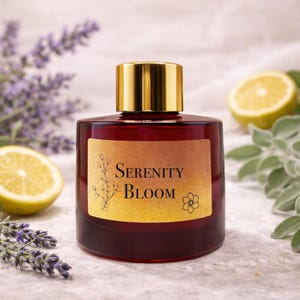 May include: A dark red glass perfume bottle with a gold cap and a gold label that reads "Serenity Bloom." The bottle is surrounded by lavender, lemon slices, and sage leaves.