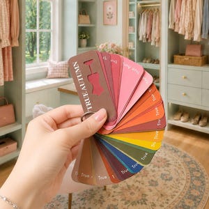May include: A fan-shaped colour swatch deck labelled TRUE AUTUMN, featuring a variety of colour samples including shades of brown, red, pink, orange, yellow, green, and blue, all held together by a metal ring through a hole in the top of each card.