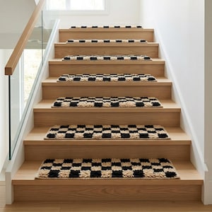 May include: A set of seven rectangular stair treads featuring a high-pile, tufted checkerboard pattern in alternating black and cream colours. Each tread is positioned centrally on individual wooden steps of a staircase with a glass railing.