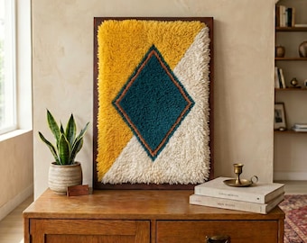 Cuadro decorativo de lana marroquí enmarcado – Decoración bohemia textil bereber en tonos azafrán, marfil y verde azulado.