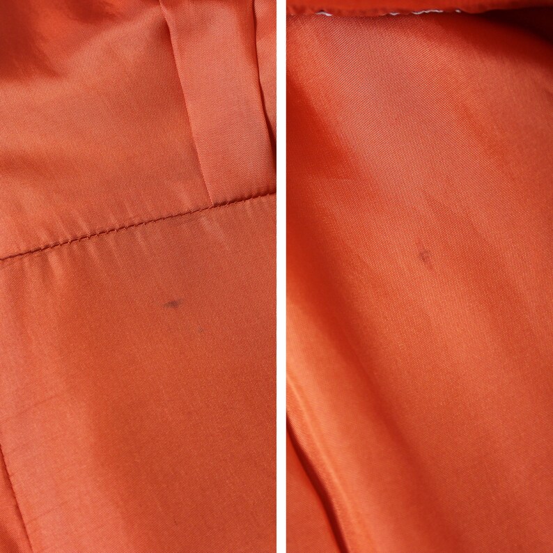May include: Close-up of a bright orange fabric with a subtle texture. The fabric has a few small dark spots.