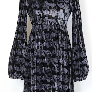 May include: Black and gray velvet dress with a floral pattern. The dress features long, voluminous sleeves and a gathered waist. The fabric has a soft, textured appearance, and the design is suitable for formal occasions.