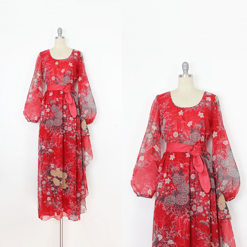 May include: A red maxi dress with a floral print and long sleeves. The dress has a gathered waist and a flowing skirt.