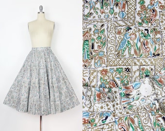 May include: A white full skirt with a colorful floral print. The skirt has a fitted waist and a full, flowing skirt. The print features a variety of flowers, leaves, and geometric patterns in shades of blue, green, red, and gold.