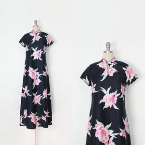 May include: A black maxi dress with a pink floral print and a mandarin collar. The dress has short sleeves and a loose fit.