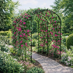 May include: A black metal garden archway featuring a curved top and vertical side supports. The structure is covered in climbing green vines with numerous vibrant magenta flowers, creating a floral tunnel over a paved stone garden path.