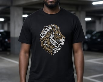 May include: A black short-sleeved t-shirt featuring a graphic of a lion's head composed of the words Courage, Strength, King, King of Kings, and Jesus in gold and white text. The design is centered on the chest of the garment.