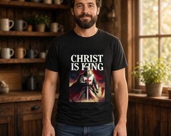 May include: A black short-sleeved t-shirt featuring a graphic print of a medieval knight in chainmail and a red cross tunic, holding a sword. Above the knight, the text reads CHRIST IS KING in bold white capital letters.