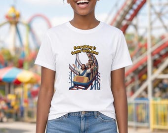 May include: A white short-sleeve t-shirt featuring a graphic print of a group of people riding a roller coaster with a figure of Jesus in the front car. The text above the illustration reads Everything is funner with Jesus.