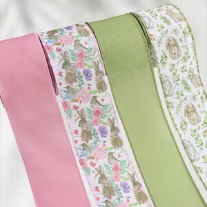 May include: Four decorative ribbons in shades of pink, green, and white. One pink ribbon is solid, while the others feature patterns of bunnies, flowers, and birds. The ribbons are likely for crafts or gift wrapping.