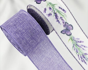 May include: Two rolls of decorative ribbon. One is a solid lavender color, the other is white with a lavender floral and butterfly design. The edges of the white ribbon are trimmed with a dark purple stitch.
