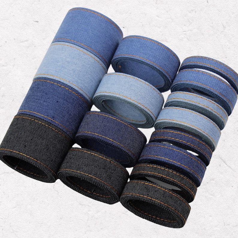 1.	Light blue denim ribbon roll in multiple widths for crafts 
2.	Blue jean fabric ribbon strips for bow making 
3.	Dark blue denim trim close-up texture detail 
4.	Black denim ribbon for sewing and DIY projects 
5.	Assorted denim ribbons in different sizes and colors 
6.	Denim ribbon used for handmade hair bows 
7.	Wide denim fabric tape for clothing decoration 
8.	Narrow denim ribbon strips for detailed craft work 
9.	Rustic denim ribbon bundle for DIY accessories