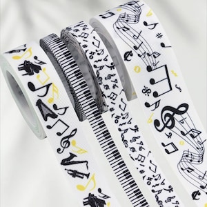 May include: Several white ribbons with musical themes. The ribbons display black musical notes, piano keys, and instruments. Some notes have yellow accents. The ribbons are rolled, ready for crafting or decoration.