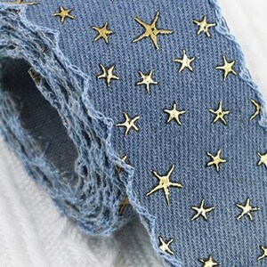 1.	Denim ribbon with embossed star pattern 
2.	Vintage washed denim ribbon for DIY crafts 
3.	3D star textured ribbon close-up 
4.	Blue jean ribbon with decorative edge trim 
5.	Black denim ribbon for fashion accessories 
6.	Textured ribbon for hair bow making 
7.	Assorted denim ribbons in multiple shades 
8.	Fabric ribbon for clothing embellishment 
9.	Stylish denim trim for handmade projects 
10.	Wide denim ribbon rolls for crafts