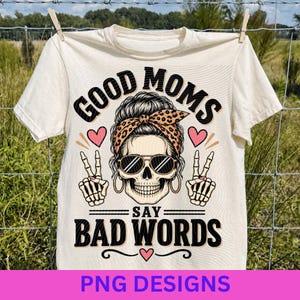 Peut inclure: Un t-shirt à manches courtes de couleur crème avec un motif de crâne portant un chignon décoiffé, un bandeau à imprimé léopard et des lunettes de soleil. Le crâne fait des signes de paix avec des mains squelettiques. Texte : GOOD MOMS SAY BAD WORDS.