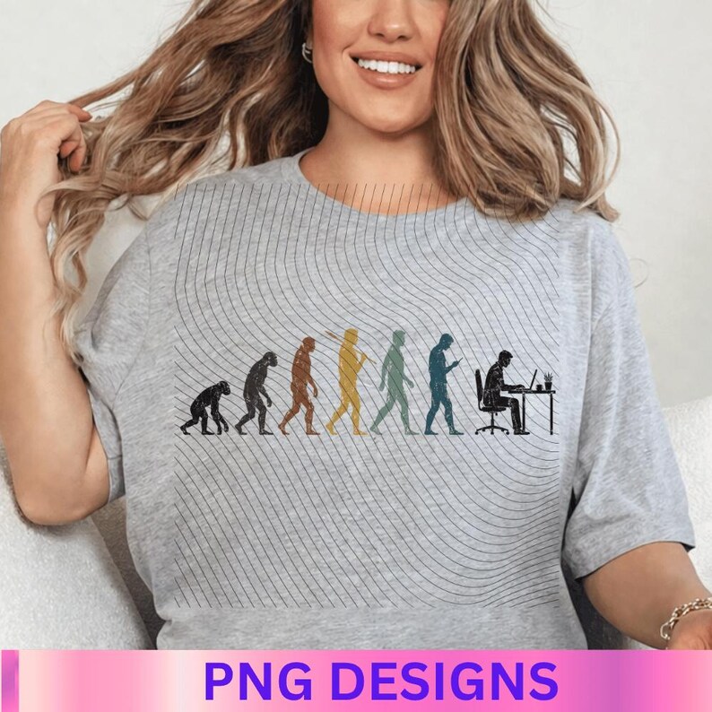 May include: A light gray t-shirt featuring a graphic print that depicts the evolution of humanity, starting from a primate and progressing through various stages to a person sitting at a desk working on a laptop computer with a small plant.