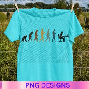 May include: A bright turquoise t-shirt featuring a black graphic print that depicts the evolution of humanity, starting from a primate and progressing to a person sitting at a desk with a computer. The design includes subtle wavy line patterns.
