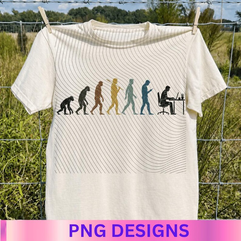 May include: A cream-colored short-sleeve t-shirt featuring a graphic print of human evolution, progressing from a primate to a person sitting at a desk with a computer. The design is overlaid with thin, wavy black lines across the fabric.