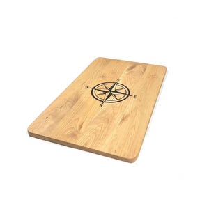 Mesa auxiliar de cerezo con forma de barco e incrustación de rosa de los vientos.