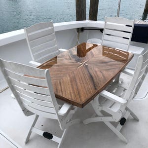 Mesa de teca con forma de barco e incrustación de rosa de los vientos