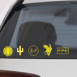 May include: Yellow vinyl stickers on a car window. The stickers include a sunburst, a cross, a circle with two vertical lines, a stylized eagle, and the letters "FPE" in a rectangle.
