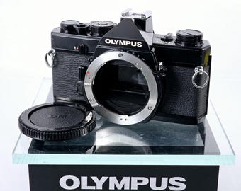 Fotocamera reflex 35 mm Olympus OM-1 MD nera, nuova, sigillata, in condizioni quasi perfette, proveniente dal Giappone.