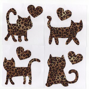 May include: Four cat-shaped and heart-shaped cutouts with a brown and black leopard print pattern. The cat cutouts are in various poses, with some having curved tails. The hearts are also in the same leopard print.