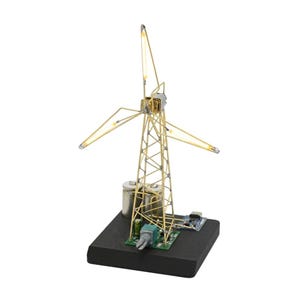 Könnte beinhalten: Ein Miniatur-Windradmodell mit goldfarbenem Rahmen und Flügeln. Das Modell enthält einen kleinen Motor, eine Leiterplatte und Batterien, alles auf einem schwarzen Sockel montiert. Die Flügel haben kleine Lichter an den Spitzen.