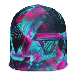 May include: A beanie hat with a vibrant, abstract design. The pattern features overlapping geometric shapes in shades of teal, magenta, and black. The hat is made of a soft, knitted material and is suitable for cold weather.