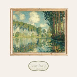 May include: A framed landscape painting depicting a serene river scene with trees and clouds. The artwork features a palette of blues, greens, and yellows, with reflections in the water. The frame is a light brown color. The text "The Painterly Cottage Co." is at the bottom.