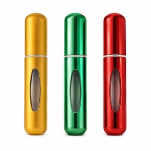 Op de afbeelding: Drie cilindrische navulbare parfumverstuivers met een metallic afwerking in goud, groen en rood. Elke fles heeft een afgeronde dop, een zilverkleurige ring bij de hals en een doorzichtig verticaal ovaal venster in het midden voor het vloeistofniveau.