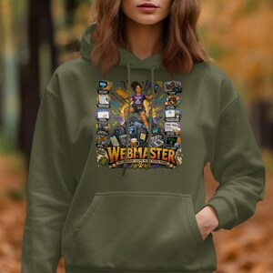 Puede incluir: Una sudadera con capucha de color verde oliva con un estampado gráfico de una persona de pie sobre una pila de equipos informáticos. El texto dice WEBMASTER THE LEGENDARY KEEPER OF THE DIGITAL KERNEL, rodeado de varios iconos y etiquetas técnicas.