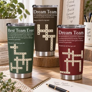 Könnte beinhalten: Drei Edelstahlbecher in Dunkelgrün, Dunkelbraun und Kastanienrot, jeweils mit einem weißen Kreuzworträtsel-Design mit Namen, dem Text "Best Team Ever" oder "Dream Team" sowie beschreibenden Sätzen über Teamarbeit und Wertschätzung.