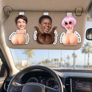 May include: Three custom car visor ornaments featuring cartoon-style figures with photographic faces. Each figure has a rounded lower body and text printed on the sides. The left reads Drive safe. Handsome. The center reads Drive safe. I fucking love you. The right reads Drive safe. I Love you.