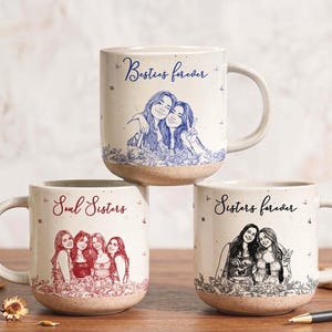 Könnte beinhalten: Drei gesprenkelte Keramiktassen mit individuellen Strichzeichnungen. Die obere Tasse zeigt den blauen Schriftzug Besties forever, die untere linke Tasse den roten Text Soul Sisters und die untere rechte Tasse den schwarzen Text Sisters forever.