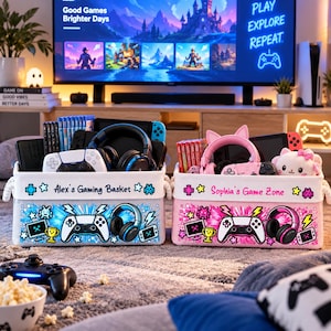 May include: Two rectangular fabric storage baskets for gaming accessories. The left basket is light blue with the text "Alex's Gaming Basket" and graphics of controllers and headsets. The right basket is pink with "Sophia's Game Zone" and similar gaming icons.