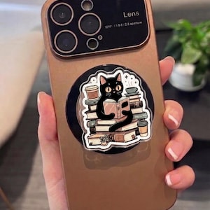 Supporto per telefono MagSafe a forma di gatto appassionato di libri – Un simpatico gatto nero che legge con una pila di libri, regalo ideale per gli amanti dei gatti e dei libri.