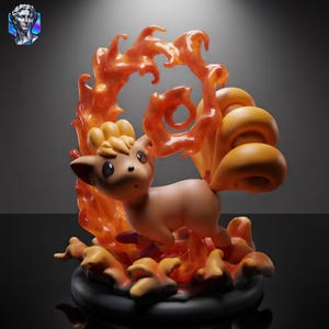 Peut inclure: Une figurine de créature ressemblant à un renard beige avec six queues enroulées, placée devant un effet de flammes orange et rouge translucides. La figurine repose sur une base noire circulaire, entourée d'éléments de feu sculptés.