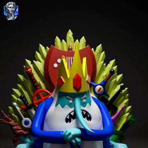 May include: A detailed figurine of the Ice King from Adventure Time, seated on a throne. The figure is predominantly blue and white, with a yellow crown adorned with red gems. The throne is decorated with swords and green accents against a dark background.