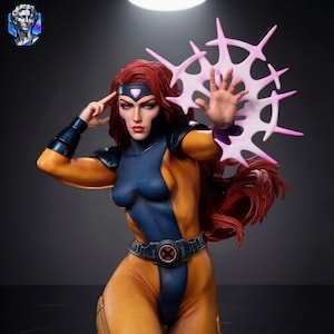 May include: A collectible statue of a character with long red hair, wearing a blue and yellow bodysuit with a black belt featuring a red X emblem. The figure has a headband with a pink gem and displays a pink, star-shaped energy effect from one hand.