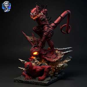 May include: A detailed figurine of a battle scene featuring Spider-Man and a red, monstrous figure. The red figure is posed aggressively, with glowing eyes and a long tail. Spider-Man is on the ground, in a defensive position. The base is a dark gray.