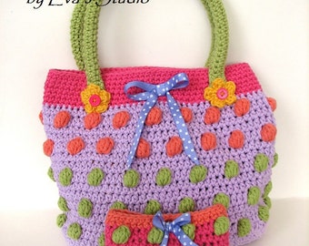 Könnte beinhalten: Eine gehäkelte Handtasche mit einem grünen Henkel und einem pink-, lila- und grün-gepunkteten Muster. Die Tasche hat eine passende kleinere Tasche mit einem pink-, lila- und grün-gepunkteten Muster. Der Text "Crochet Pattern by Eva's Studio" ist auf dem Bild zu sehen.