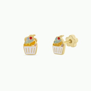 May include: A pair of gold-colored cupcake stud earrings. Each earring features a colorful cupcake design with a red cherry on top. The earrings have a post and butterfly backing for secure wear.