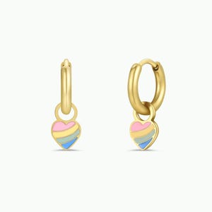 May include: A pair of gold-colored hoop earrings, each with a heart-shaped charm. The charms are painted with horizontal stripes of pink, yellow, and blue. The earrings are displayed against a white background.