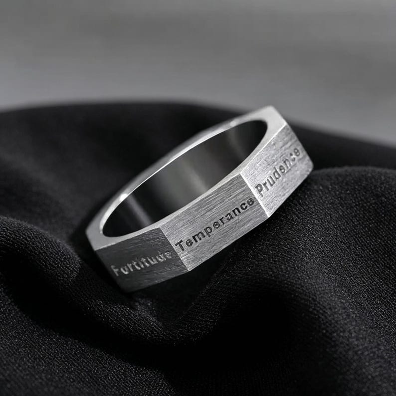 Peut inclure: Une bague en m&eacute;tal argent&eacute; avec une bande ext&eacute;rieure hexagonale au fini bross&eacute;. Les surfaces plates de la bague sont grav&eacute;es des mots Fortitude, Temperance et Prudence dans une police sans empattement, cr&eacute;ant un aspect g&eacute;om&eacute;trique distinct.