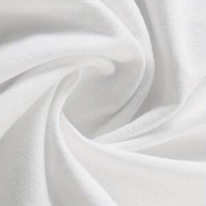 May include: Close-up of white fabric with soft folds and subtle texture. The fabric appears to be a knit or jersey material, with a smooth surface and gentle shadows. The image highlights the fabric's drape and the play of light.