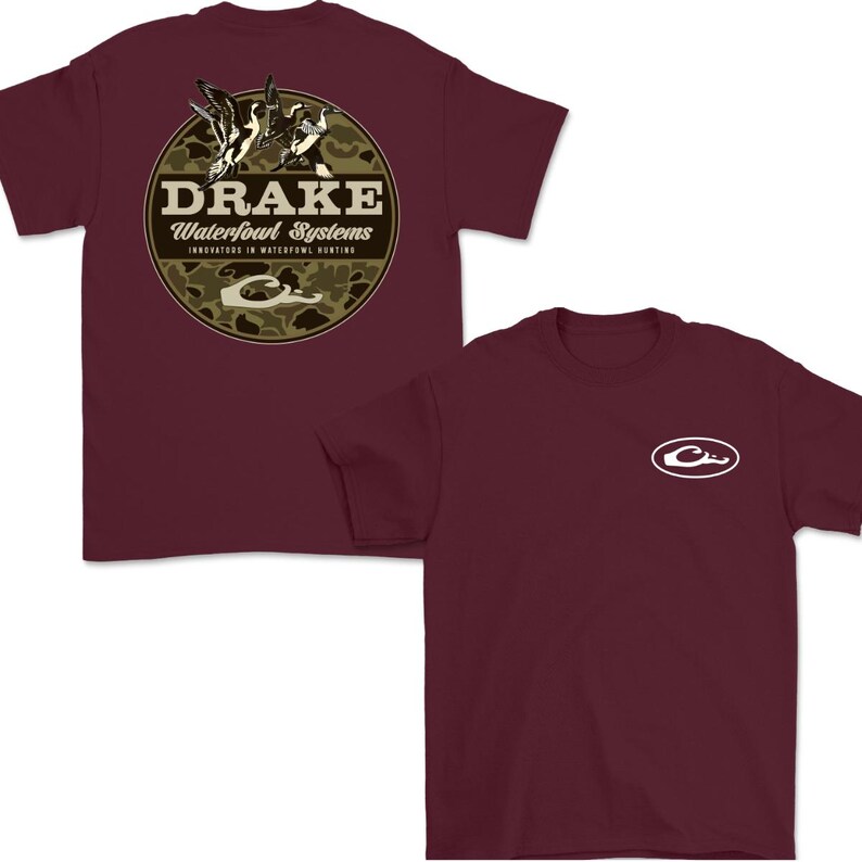 May include: Two maroon t-shirts. One features a circular design with the text "DRAKE Waterfowl Systems" and a duck illustration on a camouflage background. The other shirt has a white logo on the chest.