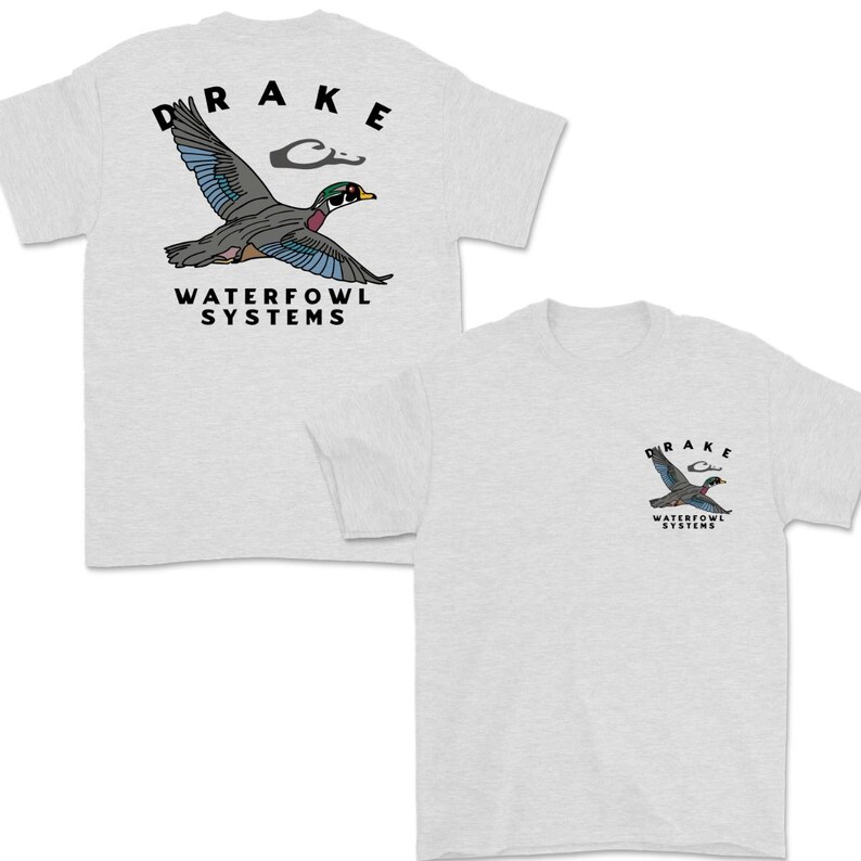 May include: Two light gray t-shirts. One shirt features a large graphic of a flying duck with the text "DRAKE" above and "WATERFOWL SYSTEMS" below. The other shirt has a smaller version of the same graphic on the chest.